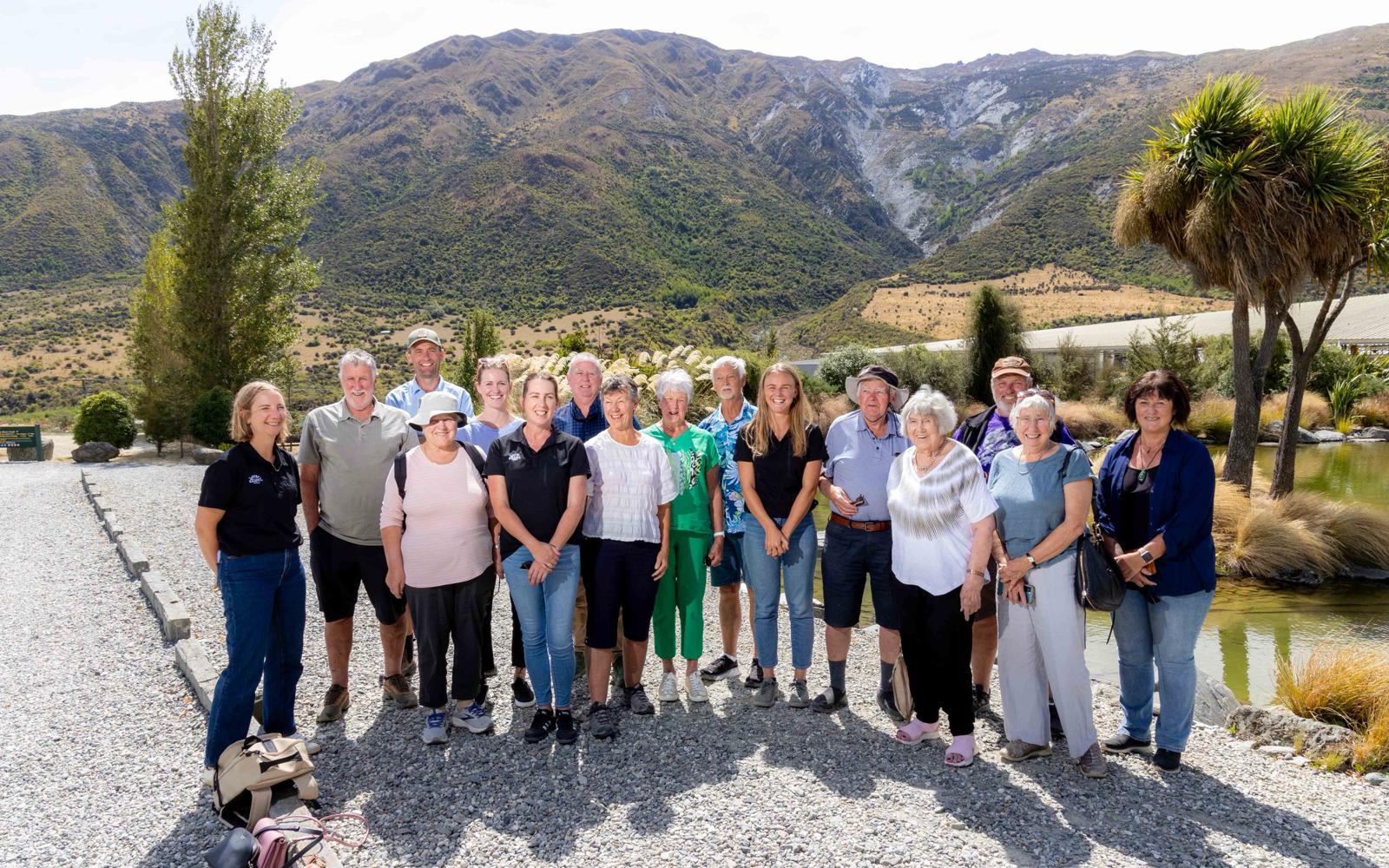 Study tour group gathered in front of the Southern Alps beside a high-country pond.