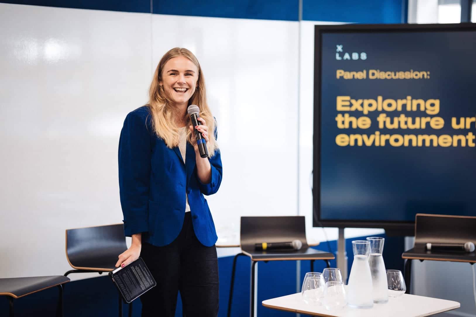 Speaking with a microphone at an X Labs panel event.